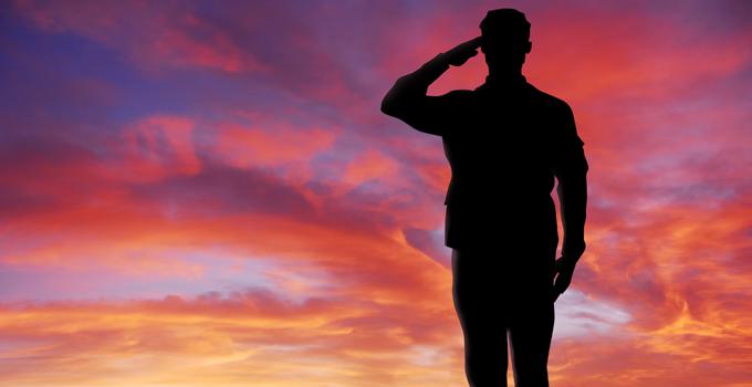 A soldier salutes into the sunset.